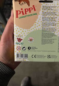 Papemballage til "Pippi Langstrømpe," med et farverigt design med gule prikker, produktdetaljer og advarsler om sikkerhed på flere sprog.