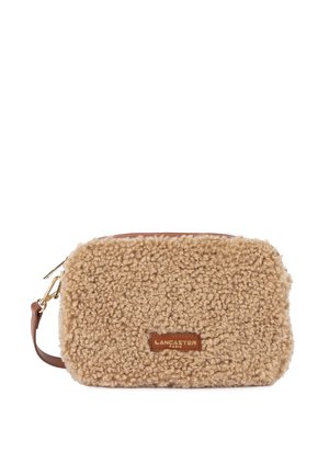 Borsetta in shearling marrone con superficie fuzzy beige, dotata di un accento in pelle e chiusura con zip dorata. Logo "LANCASTER" visibile.