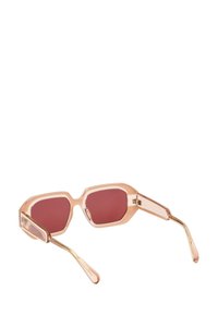 Occhiali da sole esagonali con montatura trasparente rosa, lenti bordeaux e braccia con accenti dorati. Dettagli trasparenti vicino alle cerniere.