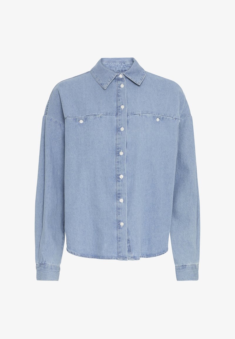 Camicia in denim azzurro chiaro con chiusura a bottoni, maniche lunghe, colletto a punta e due tasche sul petto. Il tessuto appare morbido con una leggera texture.