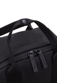 Svart tygväska med texturerad yta, dubbla dragkedjor och robusta vävda remmar. Har en tryckknapp och en minimalistisk design.