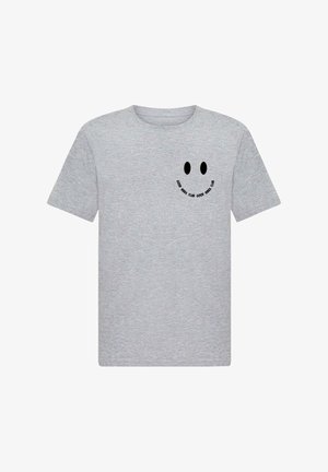 T-shirt en coton gris avec un graphique de smiley noir et le texte "BONNES VIBES CLUB" en motif circulaire sur la poitrine. Manches courtes.
