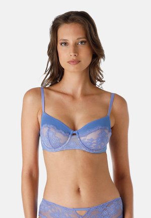 Bra blu in pizzo con pannelli in rete, supporto con ferretto, spalline sottili e regolabili, e un piccolo fiocco decorativo al centro.