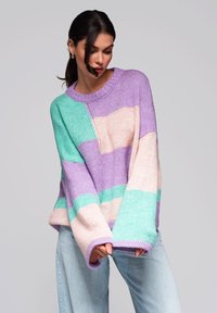 Pull en tricot oversized avec des blocs de couleurs pastel en turquoise, lavande et rose doux. Poignets côtelés et encolure ronde.