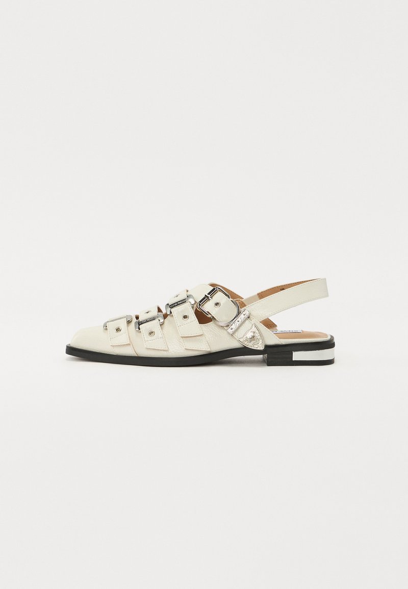 Hvite skinn slingback sandaler med flere brede stropper og sølvspenner; flat såle med en liten svart hæl og metalliske aksenter.