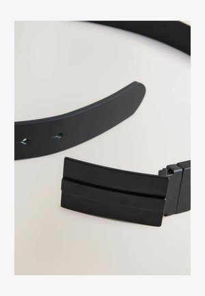 Czarny pasek wykonany z gładkiego materiału syntetycznego z prostokątną, płaską klamrą. Posiada teksturowany pasek z otworami do regulacji.