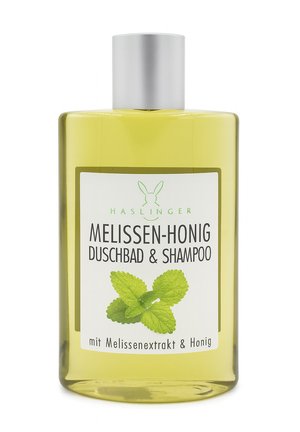 Gelbe Flasche Haslinger Melissa Honig Duschgel und Shampoo mit silbernem Verschluss und grünen Zitronenmelissenblättern auf dem Etikett.