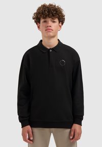 Zwarte long-sleeve polo shirt met een kraag, voorzien van een klein rond logo op de linkerborst. Gemaakt van een gestructureerde stof met geribde manchetten.
