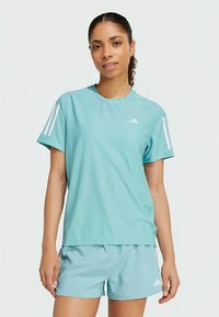 Svijetloplavi atletski majica s kratkim rukavima i okruglim izrezom, s tri bijele pruge na svakom ramenu i malim logotipom na prsima.