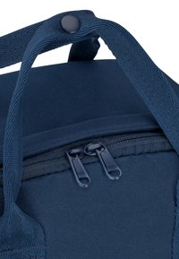 Borsa in tessuto blu navy con chiusura a doppia zip, spallacci robusti e finitura testurizzata. Presenta un pulsante a scatto per una maggiore sicurezza.