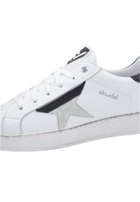 Białe sneakersy z czarnymi i srebrnymi akcentami, z teksturowaną gumową podeszwą i sznurowanym zapięciem. Szczegół w kształcie gwiazdy po boku.