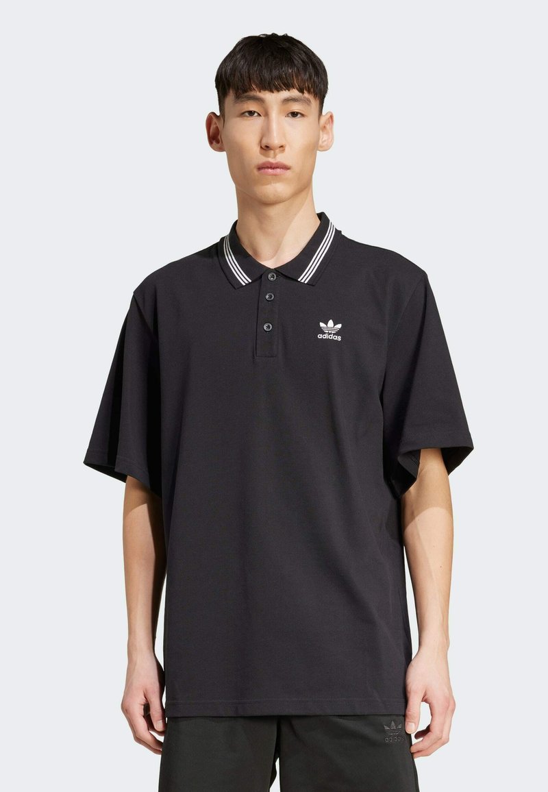 Black polo shirt with a ribbed white-striped collar, three-button placket, and a white logo on the left chest. Relaxed fit and short sleeves.