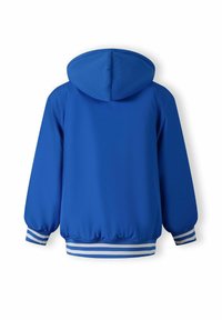 Giacca blu con cappuccio, dotata di polsini ed orlo elasticizzati, con dettagli a righe bianche e blu. Texture liscia, design casual e materiale leggero.