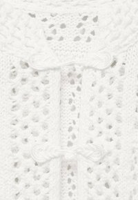 White knitted cardigan with a loose, open weave. Features two braided ties at the front and a textured, patterned surface.