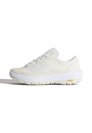 Niskoprofilowy biały sneaker z teksturowaną cholewką, grubą białą podeszwą Vibram i białymi sznurowadłami, pokazany z boku na białym tle.