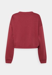 Mörkröd kort sweatshirt med långa ärmar, ribbade muddar och rundad halsringning sedd bakifrån mot en vit bakgrund.