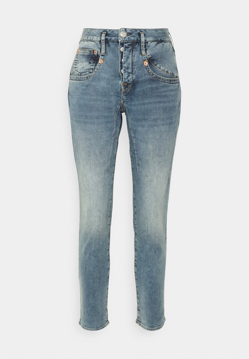 Jean en denim bleu taille haute avec effet délavé, braguette boutonnée, poches avant et jambes fuselées et ajustées.