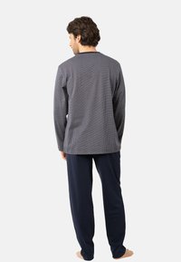 Ensemble de détente bleu marine comprenant un haut à manches longues avec un motif texturé gris et un pantalon ample assorti, fabriqué en tissu doux.