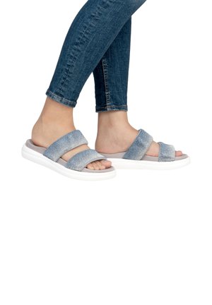Sandales à glissière en denim bleu avec deux larges bandes, une semelle intérieure grise douce et une épaisse semelle blanche. Accents en tissu texturé sur les bandes.
