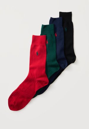 Quatre paires de chaussettes côtelées mi-mollet en rouge, vert, bleu marine et noir, chacune avec un petit logo brodé près du bord-côte.