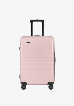 Roze harde koffer met een slank ontwerp, voorzien van horizontale lijnen, een uitschuifbare zwarte handgreep en draaibare wielen voor gemakkelijke mobiliteit.