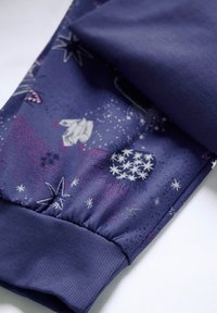 Marineblauwe stof met een kosmische print met sterren en planeten. Elastische manchetten aan de onderkant verbeteren de grip en pasvorm.