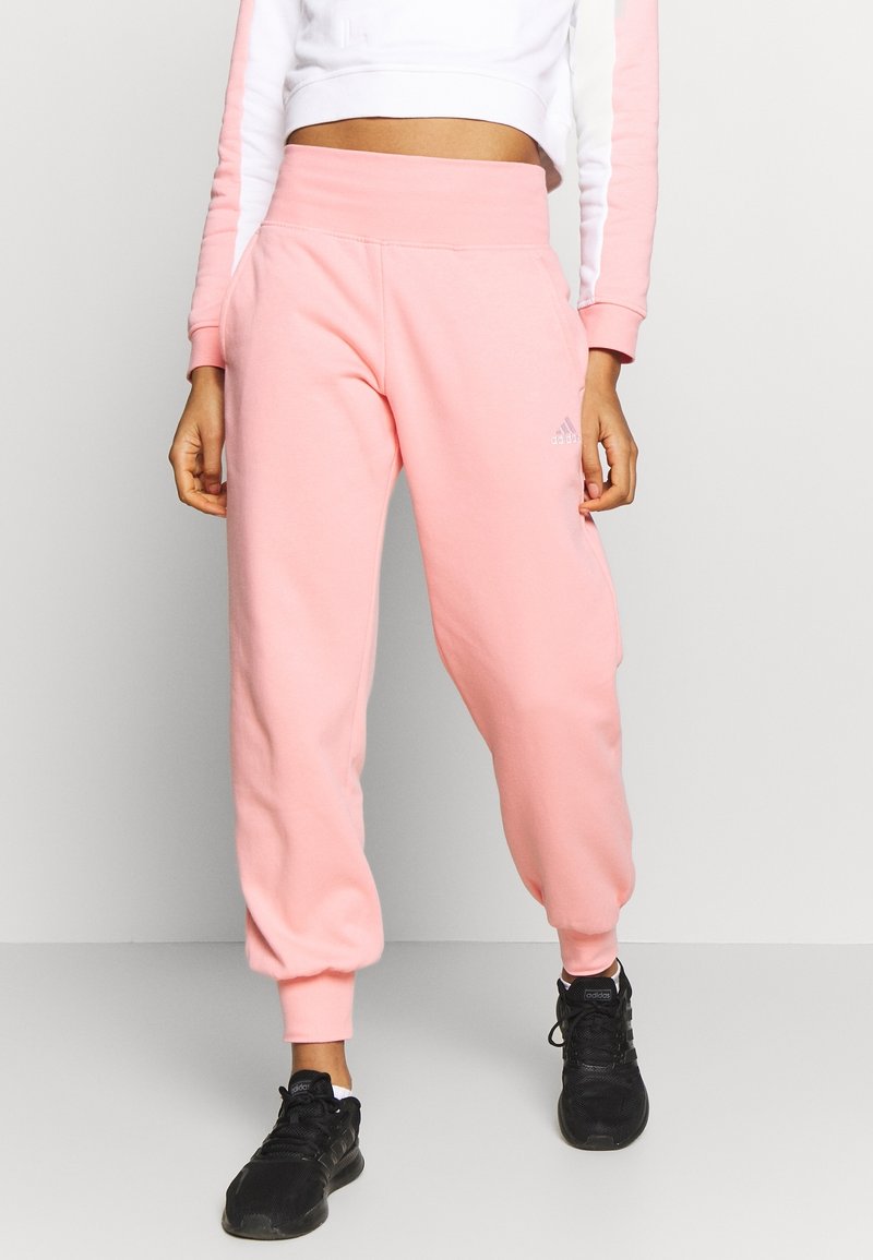 Vaatteet vaaleanpunaiset collegehousut, joissa on kapeneva lahje ja joustava vyötärö. Valmistettu pehmeästä materiaalista, jossa on pieni logo vasemmalla puolella.