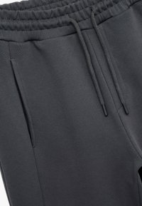 Grijze sweatpants met een elastische tailleband, trekkoord en zijzakken. Gemaakt van zachte stof met een gladde, gestructureerde afwerking.