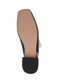 Zapato negro de tacón con puntera redondeada, parte superior lisa y suela de goma texturizada. La suela es de color marrón claro con líneas sutiles para ofrecer agarre.