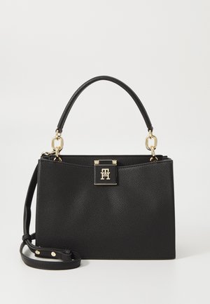 Black leather handbag with a textured finish, gold hardware, a top handle, and a detachable shoulder strap. Features a closure with a logo plaque.