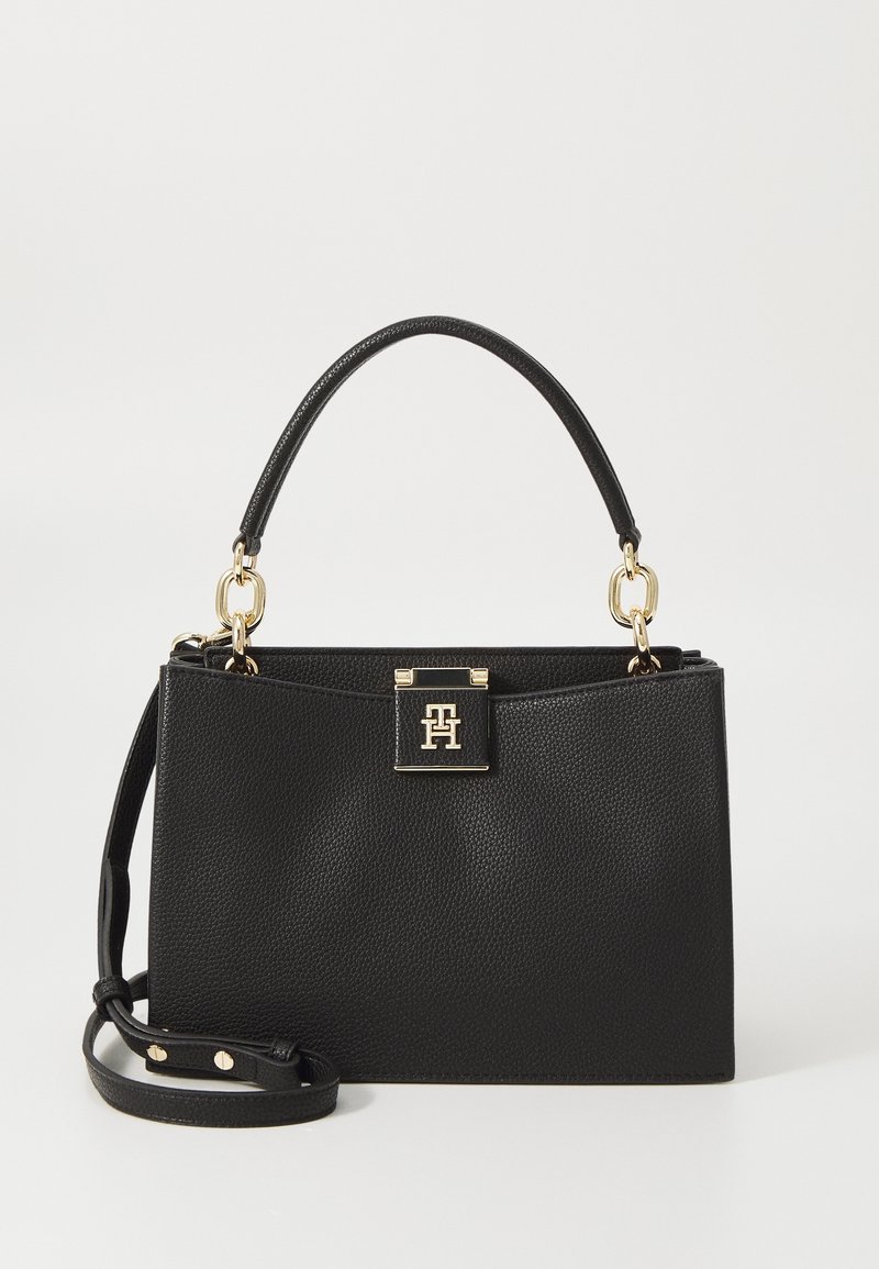 Black leather handbag with a textured finish, gold hardware, a top handle, and a detachable shoulder strap. Features a closure with a logo plaque.