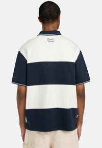 Short-sleeve polo shirt featuring navy and white horizontal stripes, a ribbed collar, and "Please Think." embroidered on the back.
