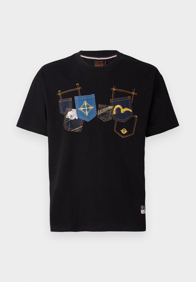 T-shirt en coton noir avec des designs colorés brodés sur la poche en bleu, jaune et beige. Encolure ronde et manches courtes.