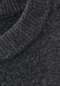 Tessuto lavorato a maglia di un grigio scuro con una superficie morbida; i dettagli includono un collo a coste e una superficie leggermente pelosa. Nessun motivo o accento visibile.