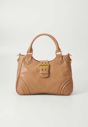 Bolso de cuero color canela con asas redondeadas, detalle de hebilla dorada y sutiles acentos de costura sobre un fondo liso y claro.