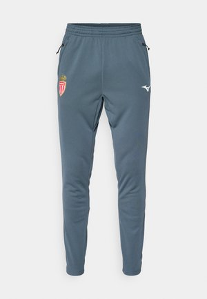 Pantalons de sport bleus avec taille élastique, poches zippées sur les côtés, emblème du club de football AS Monaco sur la cuisse gauche et logo Mizuno sur la cuisse droite.