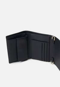 Cartera de cuero negro con una textura suave, que cuenta con múltiples ranuras para tarjetas, un compartimento para billetes y un acento de hardware en tono dorado.