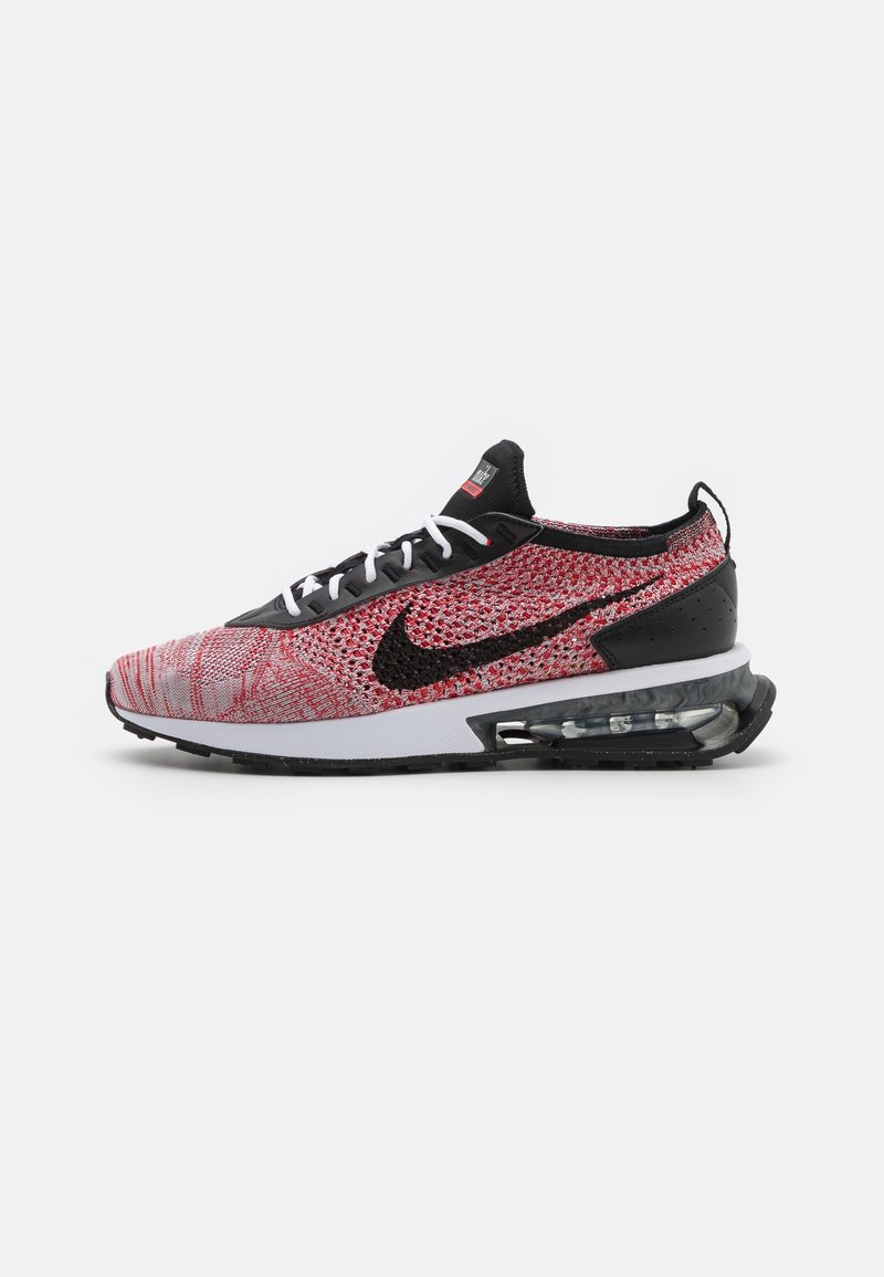 Baskets Nike tricotées rouges et noires avec lacets blancs, swoosh noir et coussin d'air visible dans la semelle noire et blanche.