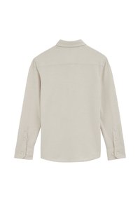 Bézs hosszú ujjú ing galléros nyakkal, gombos mandzsettával és sima textúrával; egyszínű mintával és ívelt szegéllyel rendelkezik.