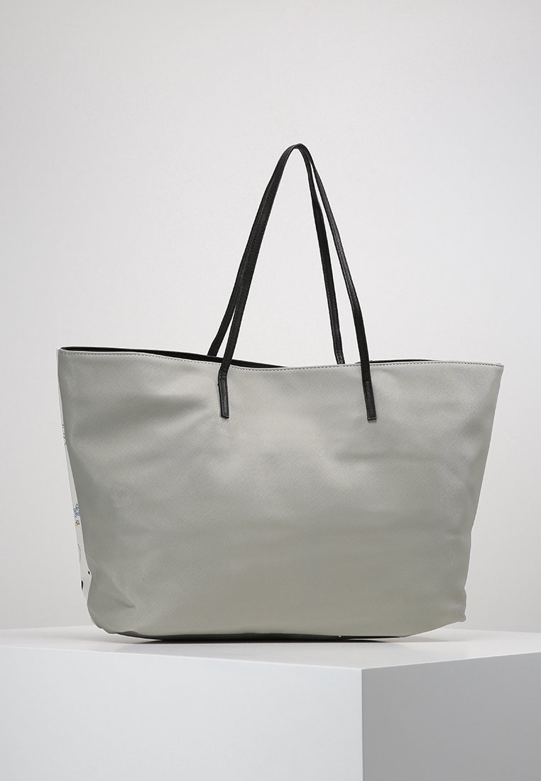 Sac cabas gris à finition texturée, avec des poignées doubles noires et une ouverture supérieure. Présente un design minimaliste sans éléments métalliques visibles ni motifs.