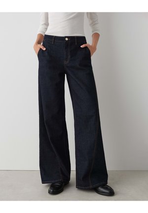 Jeans a vita alta e gamba larga in denim scuro, dotati di cuciture a contrasto, tasche laterali e chiusura anteriore con bottone. Tessuto liscio.