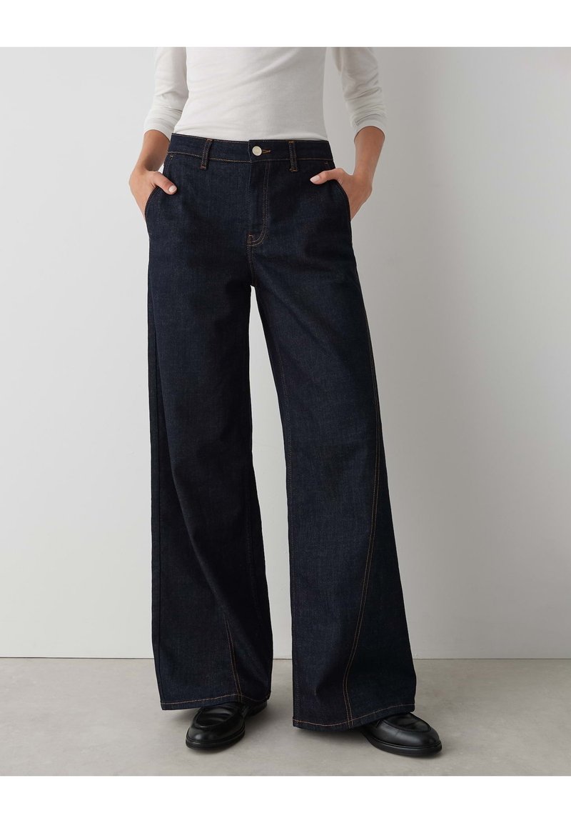 High-waisted, wide-leg jeans in dark denim, featuring contrast stitching, side pockets, and a front button closure. Smooth texture.