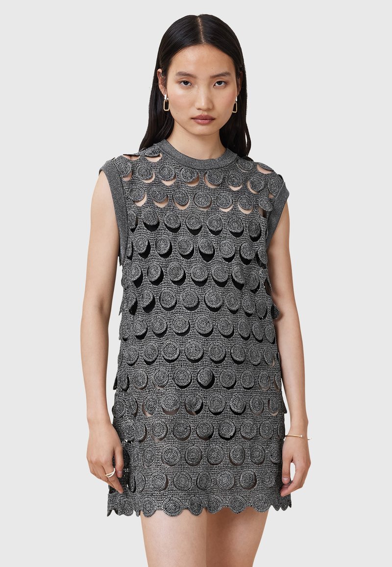 Rochie fără mâneci, de culoare neagră, cu un model circular stratificat, având un țesătură texturată și un tiv in undă. Detalii decupate vizibile pe întreaga rochie.