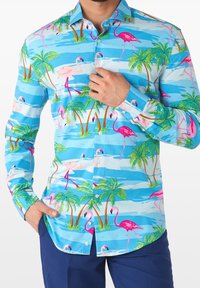 Camisa de botones colorida que presenta un fondo azul con flamencos tropicales y palmeras. Elaborada con una tela ligera y un diseño estampado.