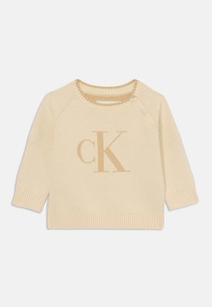 Maglione lavorato a maglia color crema con scollatura rotonda, maniche corte e dettagli a coste. Presenta un logo "CK" beige chiaro sul fronte.