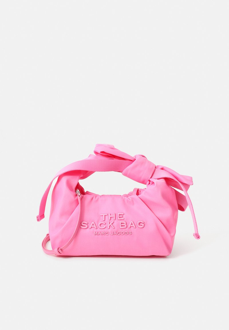 Heled roosa käekott sõlmitud käepidemega, millel on pealgraveeritud tekst "THE SACK BAG" ja "MARC JACOBS" esiküljel.