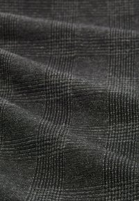 Tkanina w kratę w odcieniach czerni i szarości. Tkany wzór z drobnymi kratkami i miękką fakturą, podkreślający równomierny wzór na całej powierzchni.