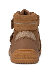 Zapato alto marrón que combina materiales de ante y cuero, acentos laterales texturizados, correas ajustables de velcro y una suela de goma con dibujo.