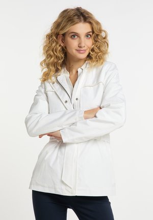 Witte waterdichte jas met een ritssluiting aan de voorkant, drukknopen en een ceintuur in de taille. Heeft een gladde textuur en een kraag met subtiele stiksels.