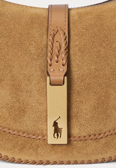 Sac en suede marron avec une bandoulière en cuir tressé et un fermoir en or arborant un logo de joueur de polo. Surface texturée et détails de couture visibles.